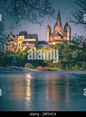 Die Kathedrale in Limburg Deutschland. Schöner Blick über eine alte Brücke mit Statue und den Fluss bei Sonnenaufgang Stockfoto