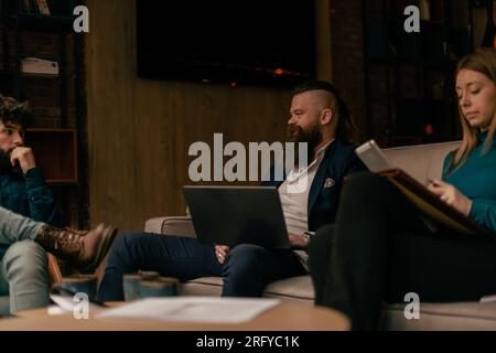 Ein langbärtiger Geschäftsmann, der mit seinen Kollegen spricht Stockfoto