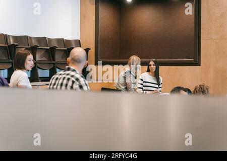Generationenübergreifende Kollegen, die während der Präsentation ein Gespräch führen Stockfoto