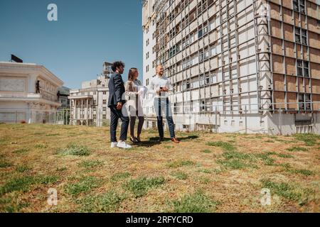 Ein junges Architekturteam, das in der Stadt arbeitet, Papierkram erledigt, plant, über ein Projekt diskutiert Stockfoto