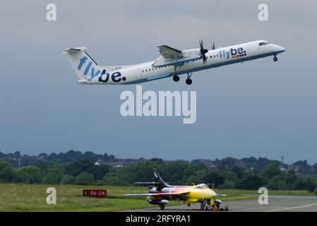 flybe Bombardier DHC-8-402 Dash 8-Flugzeug startet vom Flughafen London Southend, Essex, Großbritannien, über dem klassischen Hawker Hunter-Jet bereit für die Flugshow Stockfoto