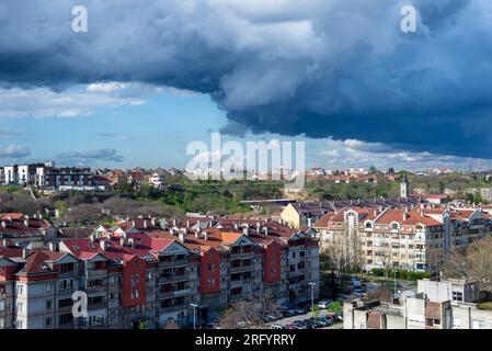 Stürmischer Himmel und regnerische Wolken über einem Viertel der Wohngebäude der Stadt Stockfoto