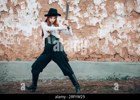 Außenporträt einer jungen Frau in Piratenkostüm mit Machete. Speicherplatz kopieren Stockfoto