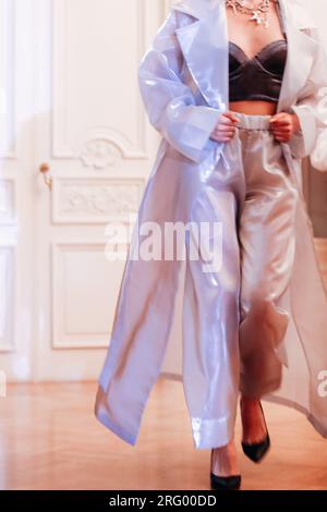 Verkürztes weibliches Modemodell in blauem Satin stilvolles Set aus Jacke und Hose Walking on the Fashion Show. Stockfoto