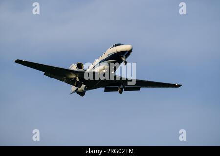 Helsinki/Finnland - 5. AUGUST 2023: Kleine Geschäftsjets nähern sich dem Flughafen mit eingeschalteten Landungslichtern. Stockfoto