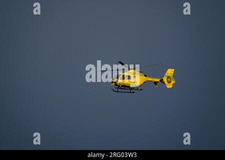 Helsinki / Finnland - 5. AUGUST 2023: Medizinischer Helikopter, betrieben von Finnhems, fliegt gegen den blauen Himmel bei Sonnenuntergang Stockfoto