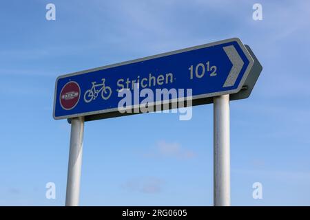 Schild „Strichen 10 1/2“ mit Radweg vor blauem Himmel. Dies ist ein Radweg-Schild in Nordost-Schottland auf der Fomartine und Buchan Way. Stockfoto