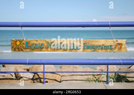 Am Fraserburgh Beach hing ein Schild an den Geländern. Es ist handgefertigt, aus Holz und trägt die Aufschrift "nichts als Fußabdrücke hinterlassen", um den Umweltschutz zu fördern Stockfoto