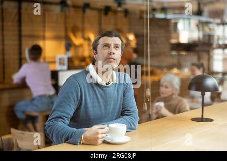 Ruhiger Mann, der Ruhe und Frieden allein in einem gemütlichen Café genießt Stockfoto