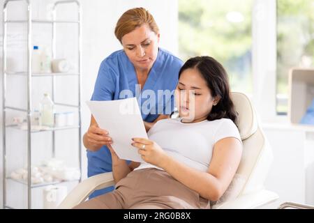 Arztberatung im mittleren Lebensalter mit Dokumenten Stockfoto