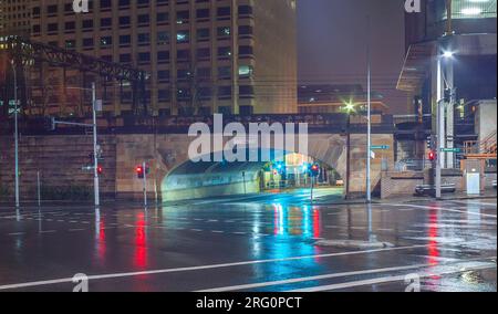 Elizabeth Street in der Campbell Street in Sydney, Australien, in einer regnerischen Nacht mit den erhöhten Bahngleisen des Hauptbahnhofs. Stockfoto