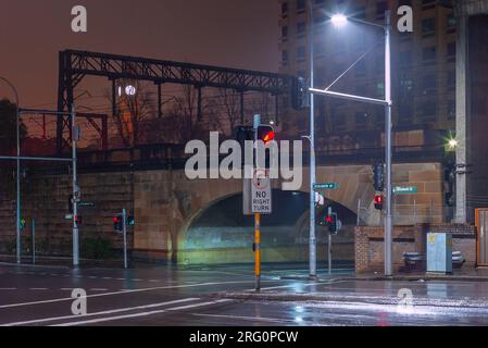 Elizabeth Street in der Campbell Street in Sydney, Australien, in einer regnerischen Nacht mit den erhöhten Bahngleisen des Hauptbahnhofs. Stockfoto