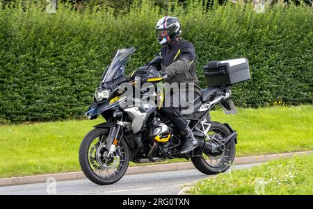 Whittlebury, Northants., Großbritannien - 6. 2023. August. BMW GS 1250 Motorrad fährt durch ein englisches Dorf. Stockfoto