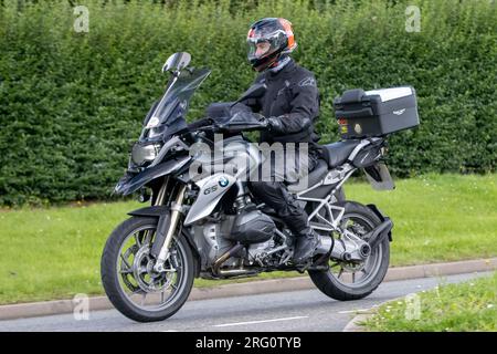 Whittlebury, Northants., Großbritannien - 6. 2023. August. BMW GS 1200motorcycle Motorrad fährt durch ein englisches Dorf. Stockfoto