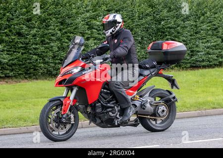 Whittlebury, Northants., Großbritannien - Aug 6. 2023. 2021 rotes Ducati Multistrada 1260 S Motorrad durch ein englisches Dorf. Stockfoto