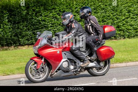 Whittlebury, Northants., Großbritannien - Aug 6. 2023. 2012 rotes Honda VFR-Motorrad, das durch ein englisches Dorf fährt. Stockfoto