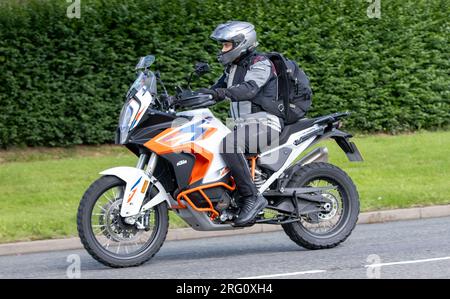 Whittlebury, Northants., Großbritannien - Aug 6. 2023. 2023 Orange KTM 1290 Super Adventure R 23 Motorrad, das durch ein englisches Dorf fährt. Stockfoto