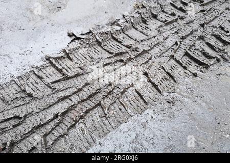 Spuren des Reifenprofils eines Autos auf einer unbefestigten Straße. Spuren von Autoreifen im Schlamm Stockfoto