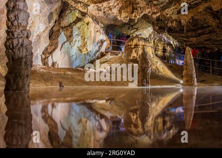 Touristen besuchen einen unterirdischen Teich mit Stalagmiten in der Höhle Belianska im slowakischen Tatra-Nationalpark Stockfoto