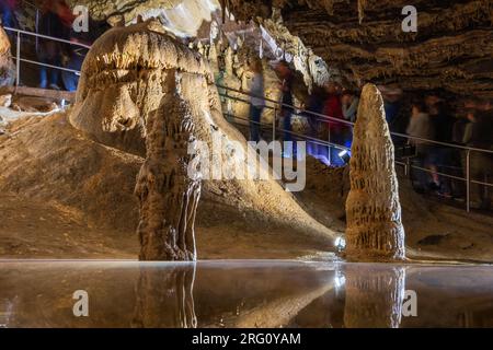 Touristen besuchen einen unterirdischen Teich mit Stalagmiten in der Höhle Belianska im slowakischen Tatra-Nationalpark Stockfoto