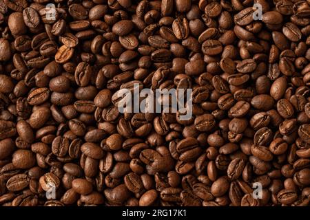 Draufsicht auf den Hintergrund mit dunkelbraunen Kaffeebohnen mit angenehmem Duft Stockfoto