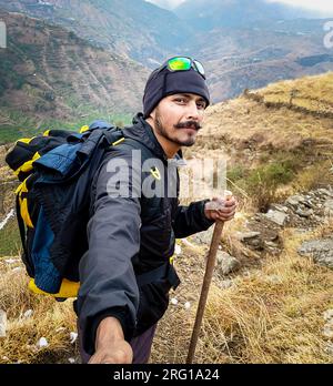 Oktober 14. 2022 Uttarakhand, Indien. Ein Wanderer mit Selfie-Stick nimmt die Wanderung in den Bergen von Nag Tibba, Uttarakhand, Indien, auf. Aufregende Produkte Stockfoto