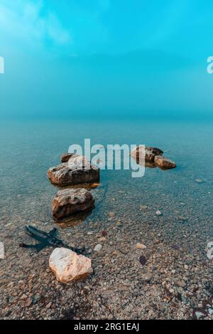 Felsen im Bohinj See im nebligen Wintermorgen, selektiver Fokus Stockfoto