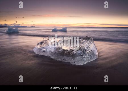 Sonnenaufgang am Diamantenstrand mit Eisberg im Vordergrund Stockfoto