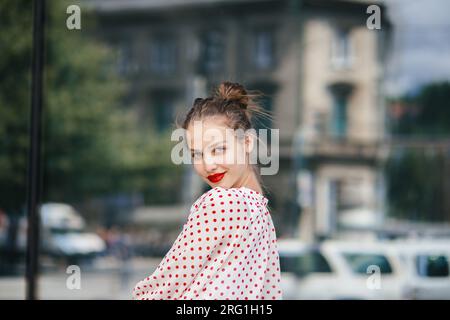 Junge schöne Frau in der Stadt, die roten Lippenstift trägt Stockfoto