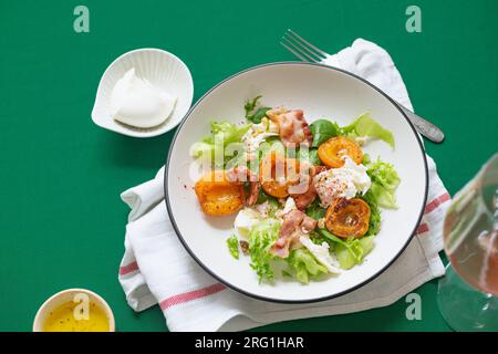 Salat mit gegrillten Aprikosen und Speck Stockfoto