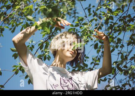 Ein junges Mädchen tanzt im Sommerwald bei sonnigem Wetter Stockfoto