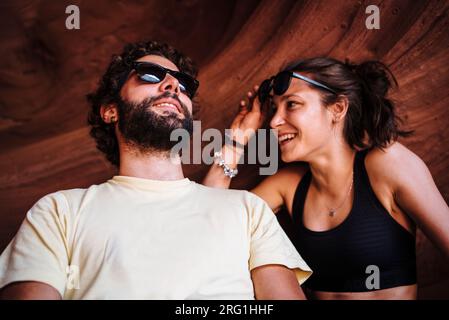 Glückliches Paar, das sich während einer Reise in einer Sandsteinhöhle ausruht. Stockfoto