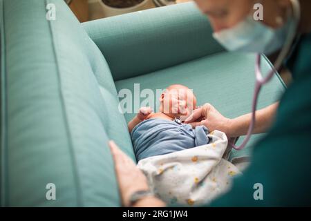 Hebamme, Arzt überprüft den Herzschlag des Neugeborenen, Vitalfunktionen Stockfoto