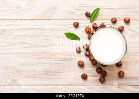 Vegane Milch aus Haselnüssen in Flaschen auf Holztisch, vegetarische Alternative Lebensmittel, sauberes Esskonzept. Draufsicht mit Kopierbereich. Stockfoto