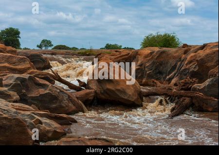 Die Lugard Falls, felsige Ufer und Felsbrocken im Galana River. Lugard Falls, Galana River, Tsavo East National Park, Kenia. Stockfoto