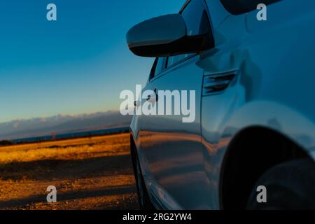 Auto auf der Wiese vor den Bergen im Herbst, aus nächster Nähe Stockfoto