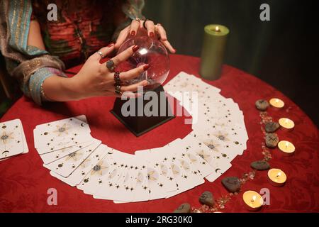 Seher mit Kristallkugel, Tarotkarten und Runen, um die Zukunft vorherzusagen Stockfoto