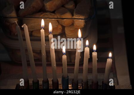 Beleuchtete Menora und eine Flasche Manischewitz auf einem Tisch während der Hannukah 2022 Stockfoto