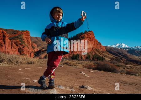 Ein Junge macht ein Selfie vor den Bergen Stockfoto
