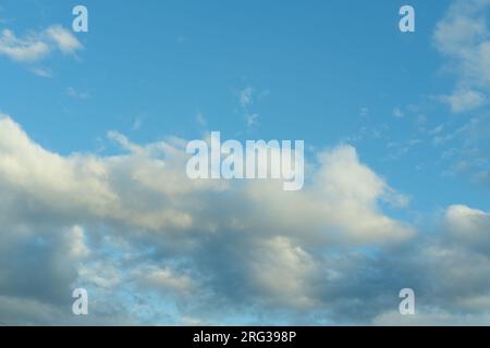 Blauer Himmel Hintergrund mit weißen flauschigen Cumulus Wolken. Panorama von weißen, flauschigen Wolken am blauen Himmel. Wunderschöner, riesiger blauer Himmel mit erstaunlichen verstreuten Stockfoto