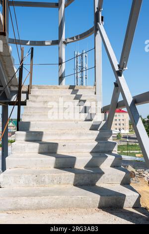 Die Architektur der Treppe ist noch nicht fertig. Treppe auf einer Baustelle. Gebäude mit Metalltreppe zum Zeitpunkt der Renovierung. Baustelle in Stockfoto