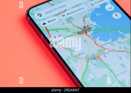 New York, USA - 21. Juli 2023: Autoverkehr in Boston google Maps auf Smartphone-Bildschirm Nahaufnahme mit rotem Hintergrund Stockfoto