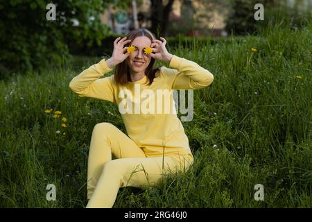 Komisches Mädchen im gelben Anzug auf dem Gras Stockfoto