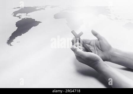 Christian hält das Heilige Kreuz Jesu Christi in der Hand und betet für Weltmissionen, Evangelismus und Weltkarte-Hintergrund Stockfoto