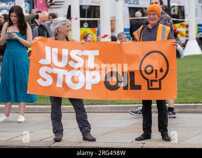 Just Stop Oil-Aktivisten mit großem Banner in Zentral-London, die sich für die Regierung einsetzen, alle zukünftigen Lizenzen und die Produktion fossiler Brennstoffe zu stoppen. Stockfoto