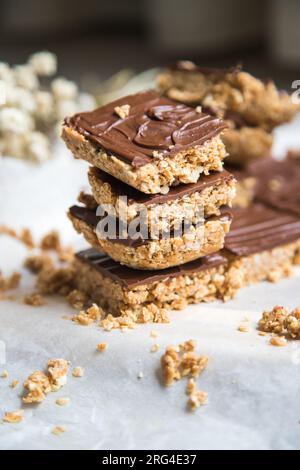 Energiereiche Hafermehlriegel oder -Quadrate aus Hafermehl, Erdnussbutter, Honig, Kokosöl, und Cashews, garniert mit Schokolade. Stockfoto