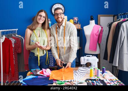 Mann und Frau Schneiderei Schneidertuch Schreiben auf Notebook in der Bekleidungsfabrik Stockfoto