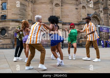 Edinburgh, Schottland, Vereinigtes Königreich, 07. August 2023. Havanna Street Party: Bunte kubanische Tänzer leuchten auf dem Bristo Square vor der McEwan Hall auf. Havana Street Party, die lebhafte Tanzshow aus Kuba, bietet Salsa, Rumba und Street Dance. Die Show zeigt Tänzerinnen und Tänzer aus einer Reihe kubanischer Tanzgruppen. Sally Anderson/Alamy Live News Stockfoto