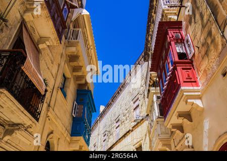 Traditionelle maltesische Kalksteingebäude mit farbigen Balkonen in den lebhaften Gassen der Altstadt von Birgu, Citta Vittoriosa ohne Menschenmassen. Stockfoto