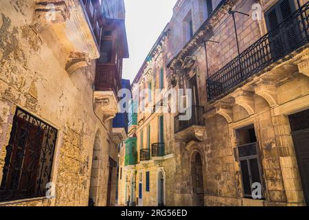 Traditionelle maltesische Kalksteingebäude mit farbigen Balkonen in den lebhaften Gassen der Altstadt von Birgu, Citta Vittoriosa ohne Menschenmassen. Stockfoto